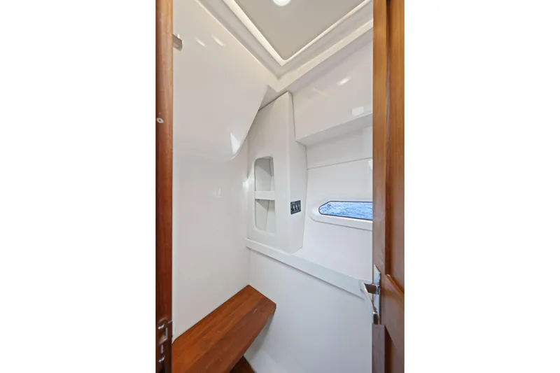  Yacht Photos Pics 2024 Regal 38 XO interior cabin with wooden accents and a small window.