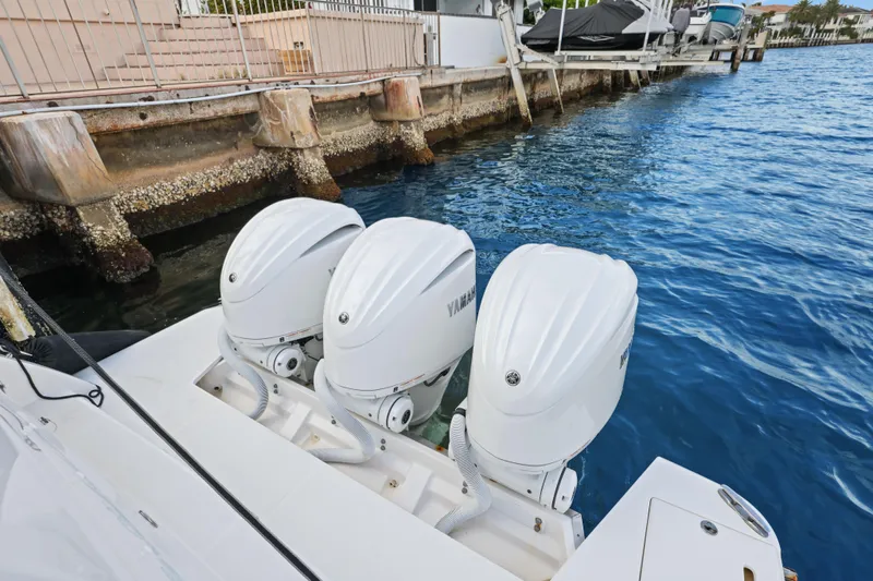  Yacht Photos Pics 2024 Regal 38 XO boat with triple Yamaha outboard engines docked by the water.