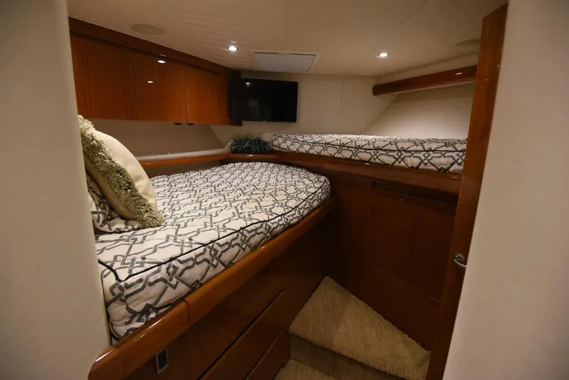 Crank It Up Yacht Photos Pics Luxurious cabin interior of 2014 Viking 62 Convertible yacht with twin beds and wooden cabinetry.
