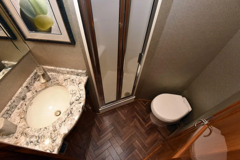 Crank It Up Yacht Photos Pics 2014 Viking 62 Convertible yacht bathroom with marble countertop, shower, and toilet.