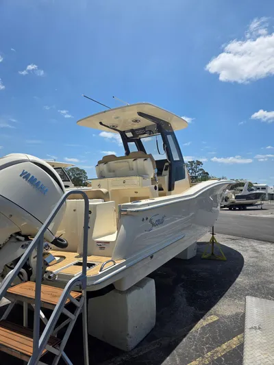  Yacht Photos Pics 2025 Scout 260 LXF boat with Yamaha engine, docked under a clear blue sky.