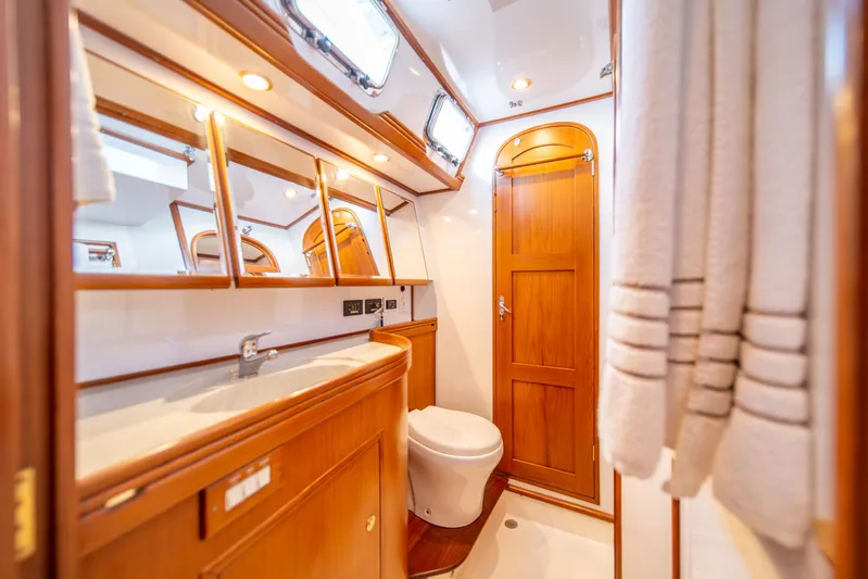 Voodoo Yacht Photos Pics Luxurious wooden bathroom interior on a 2010 Hylas 70 yacht, featuring elegant fixtures.