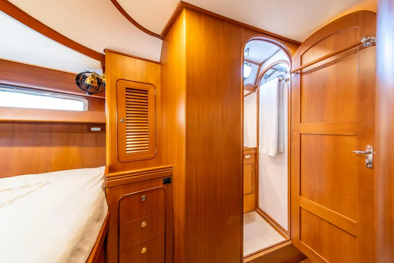 Voodoo Yacht Photos Pics Luxurious wooden interior of 2010 Hylas 70 yacht cabin with bed and bathroom.