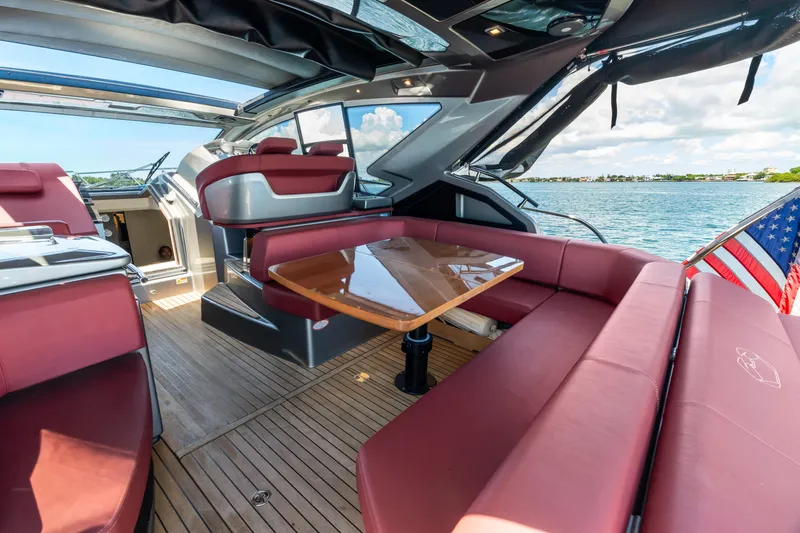Damare Yacht Photos Pics Luxurious 2022 Cranchi M 44 HT yacht interior with red seating and wooden table.