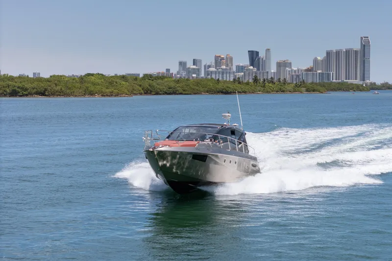 Damare Yacht Photos Pics 2022 Cranchi M 44 HT yacht cruising on water with city skyline backdrop.