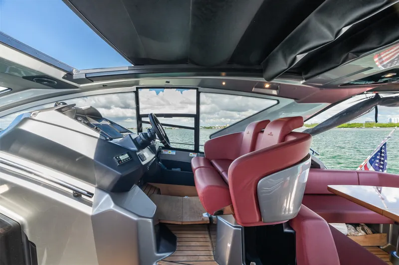 Damare Yacht Photos Pics 2022 Cranchi M 44 HT yacht interior with red seating and modern helm.