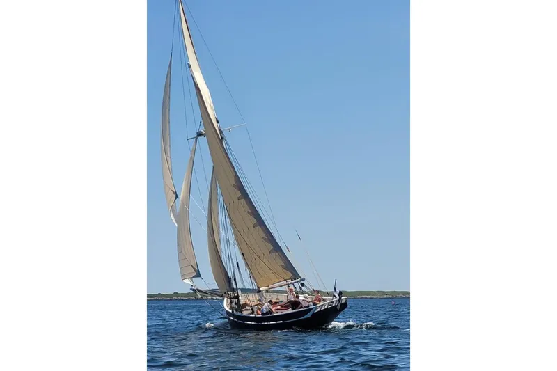 Hesper Yacht Photos Pics Custom 2004 Luke Powell Pilot Cutter sailing on open water under clear blue skies.