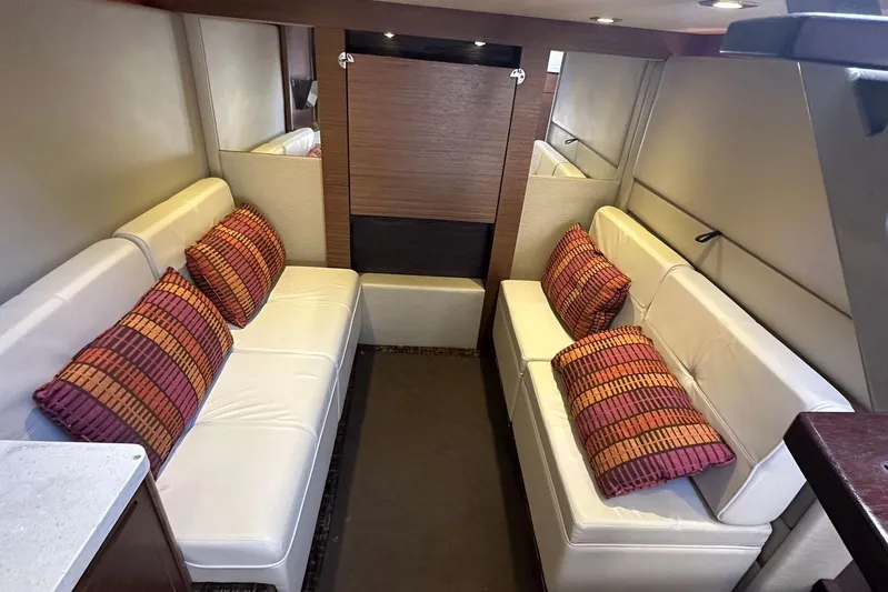  Yacht Photos Pics Luxurious interior of 2014 Sea Ray 410 Sundancer with white seating and colorful cushions.