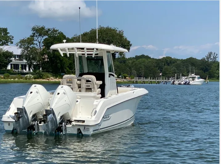 Patriot Yacht Photos Pics 2020 Boston Whaler 250 R boat on calm water, with twin engines, near a dock.