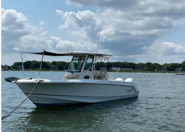Patriot Yacht Photos Pics 2020 Boston Whaler 250 R boat on calm water under cloudy sky.