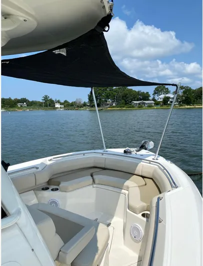 Patriot Yacht Photos Pics 2020 Boston Whaler 250 R boat with seating area and sunshade on a calm lake.
