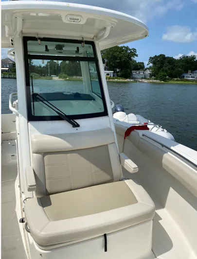Patriot Yacht Photos Pics 2020 Boston Whaler 250 R boat interior with seating, on a sunny day by the water.