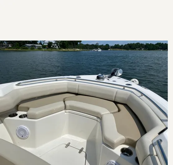 Patriot Yacht Photos Pics 2020 Boston Whaler 250 R boat interior with cushioned seating on calm water.
