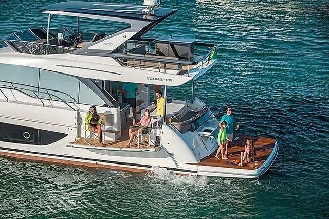  Yacht Photos Pics Luxurious Schaefer 600 yacht cruising with passengers, 2026 model, on clear blue waters.