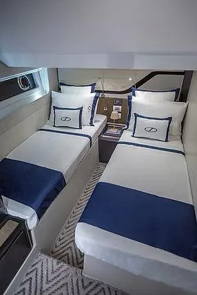  Yacht Photos Pics Luxurious twin cabin in 2026 Schaefer 600 yacht with elegant blue and white bedding.