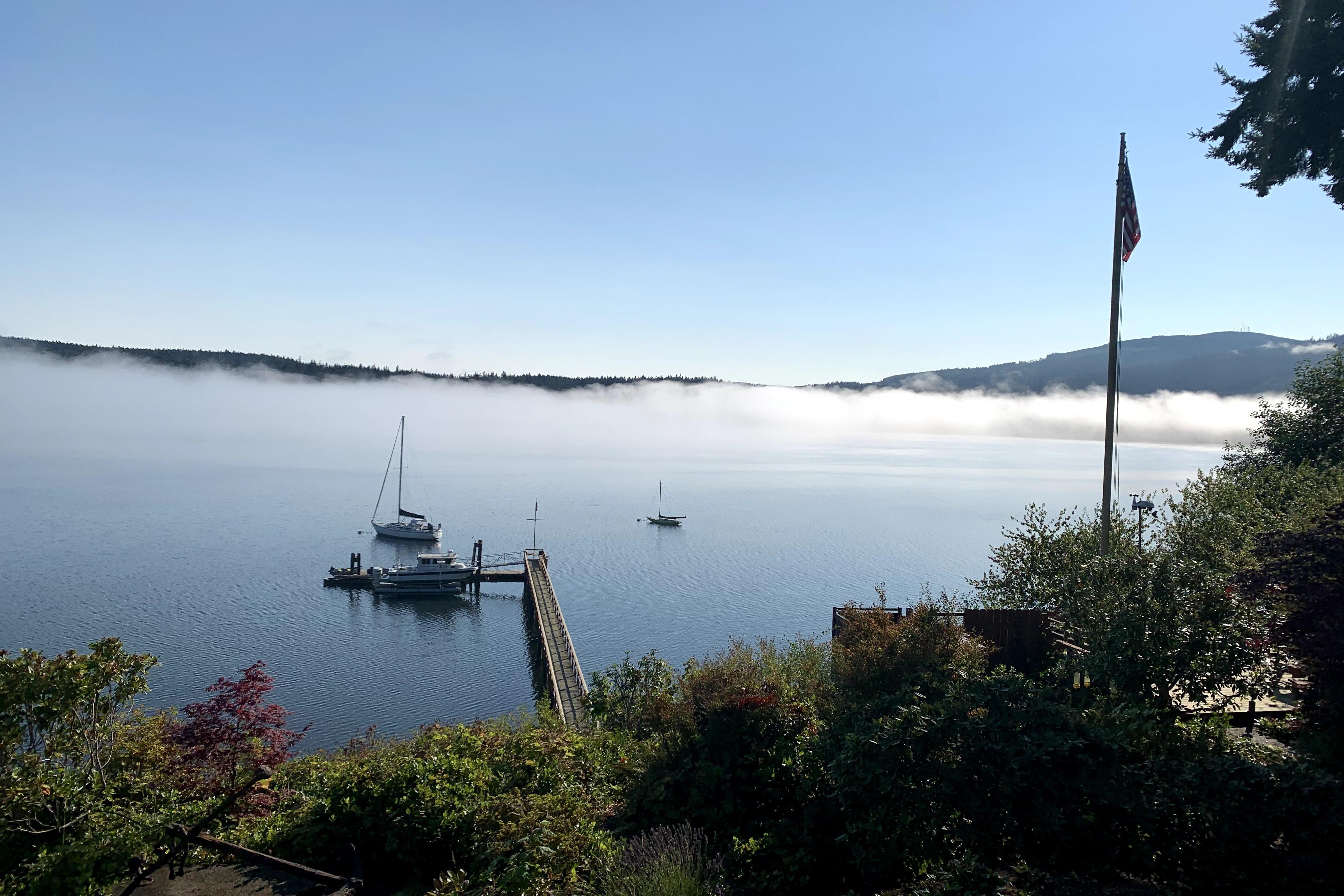 A serene harbor view with boats, mist, and a Davis Rock Harbor 25 from 1998.