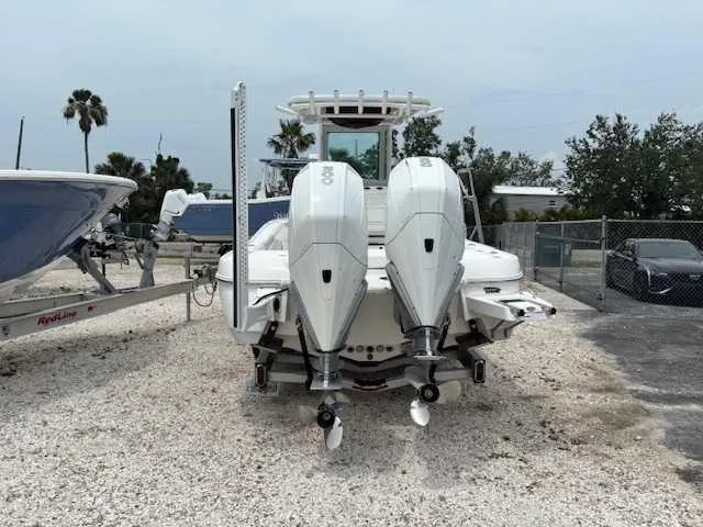 Caymas 28 Hb Twin Yacht Photos Pics 2022 Caymas 28 Twin boat with dual outboard engines, parked on gravel.