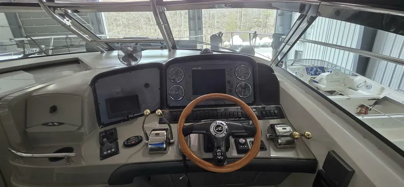  Yacht Photos Pics 2005 Sea Ray 40 Sundancer helm with wooden steering wheel and modern navigation instruments.