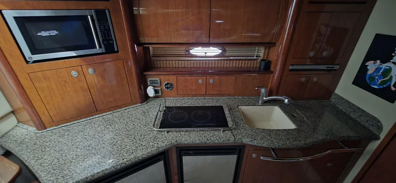  Yacht Photos Pics 2005 Sea Ray 40 Sundancer kitchen with granite countertops, microwave, stove, and sink.
