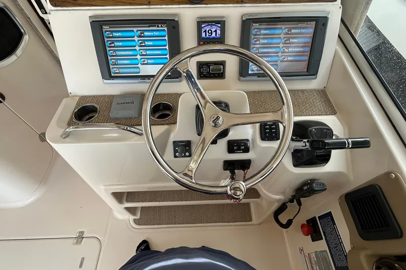  Yacht Photos Pics Control panel of 2013 Grady-White Freedom 335 boat with steering wheel and navigation screens.