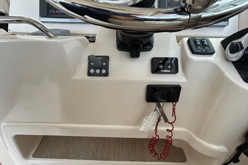  Yacht Photos Pics Control panel of 2013 Grady-White Freedom 335 boat with steering wheel and switches.