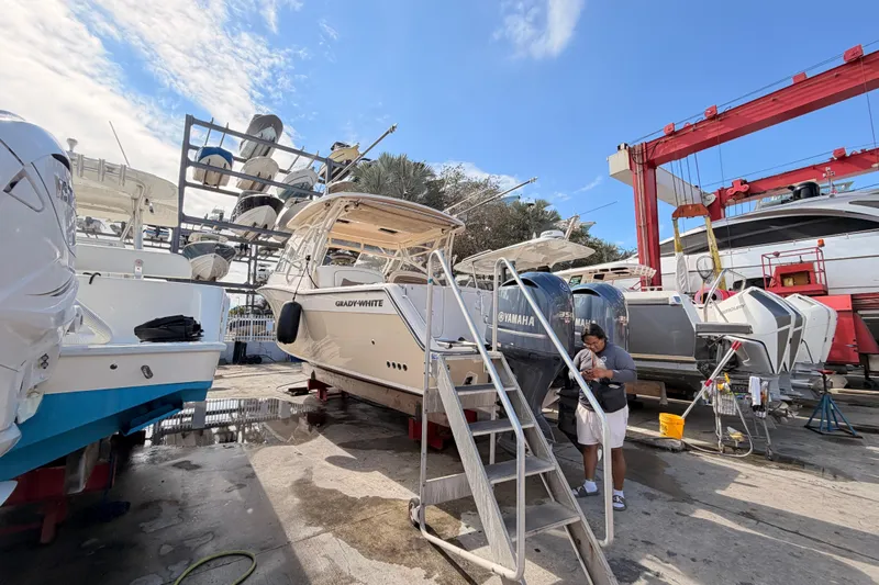  Yacht Photos Pics 2013 Grady-White Freedom 335 boat in a marina, surrounded by other vessels and equipment.