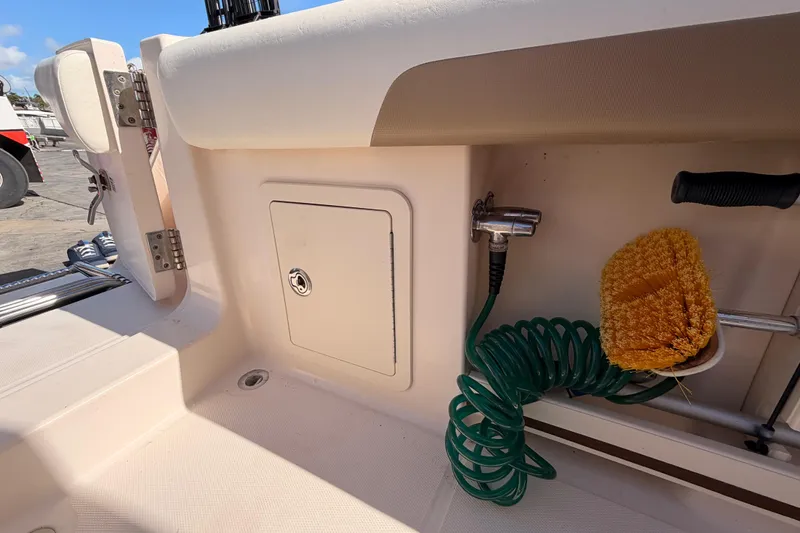  Yacht Photos Pics 2013 Grady-White Freedom 335 boat deck with storage compartment and cleaning tools.