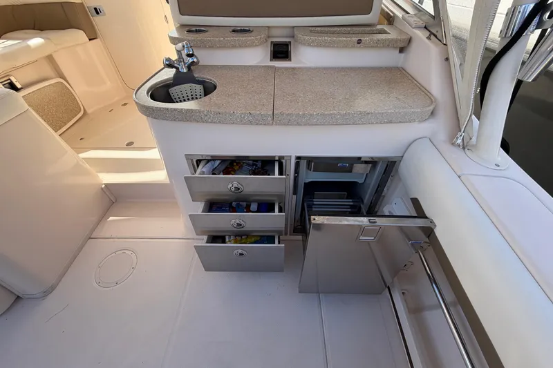  Yacht Photos Pics 2013 Grady-White Freedom 335 boat interior with sink, storage drawers, and open fridge.
