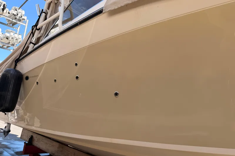  Yacht Photos Pics 2013 Grady-White Freedom 335 boat hull with fender, docked under clear sky.