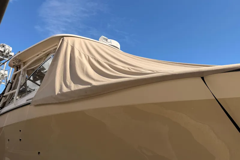  Yacht Photos Pics 2013 Grady-White Freedom 335 boat with beige cover under clear blue sky.