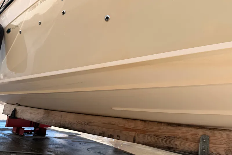  Yacht Photos Pics 2013 Grady-White Freedom 335 boat hull on wooden support, side view.