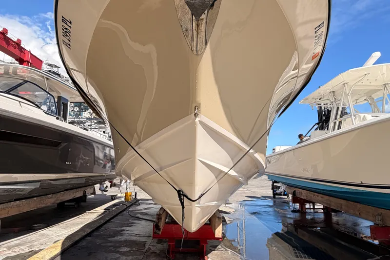  Yacht Photos Pics 2013 Grady-White Freedom 335 boat in dry dock, flanked by other vessels.