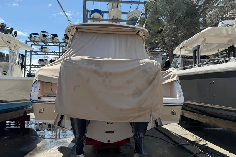  Yacht Photos Pics 2013 Grady-White Freedom 335 boat covered in tarp, docked among other boats.