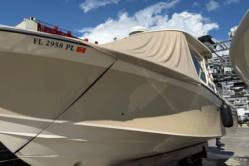  Yacht Photos Pics 2013 Grady-White Freedom 335 boat with cover, docked under a blue sky.
