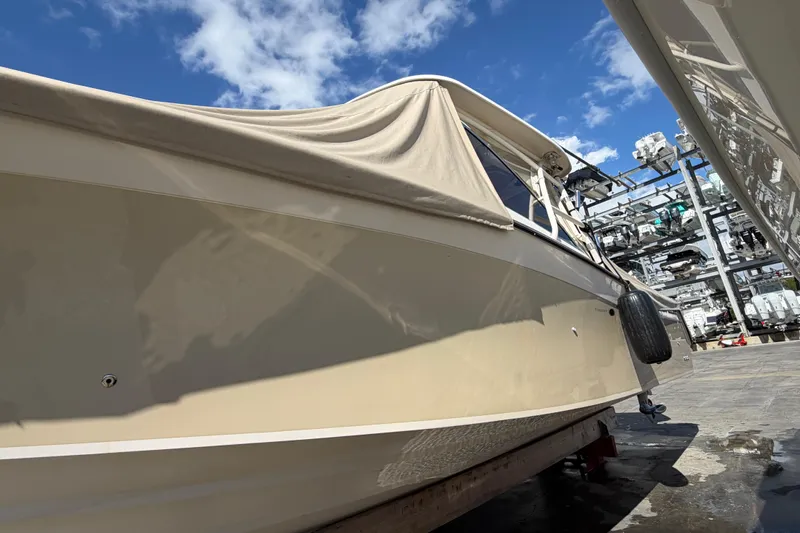  Yacht Photos Pics 2013 Grady-White Freedom 335 boat with cover, docked under a clear blue sky.