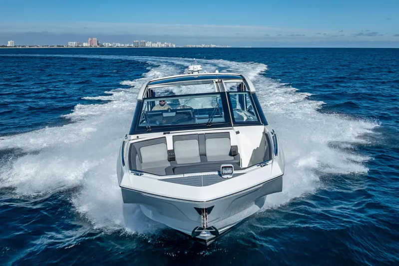  Yacht Photos Pics 2023 Galeon 375 GTO cruising on open water with city skyline in background.