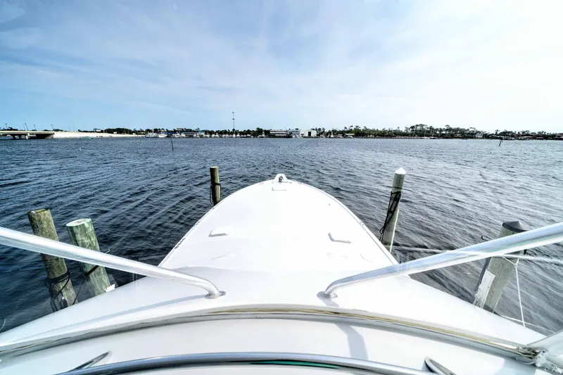  Yacht Photos Pics Bow view of 1998 Hatteras 60 Convertible yacht docked on calm water.