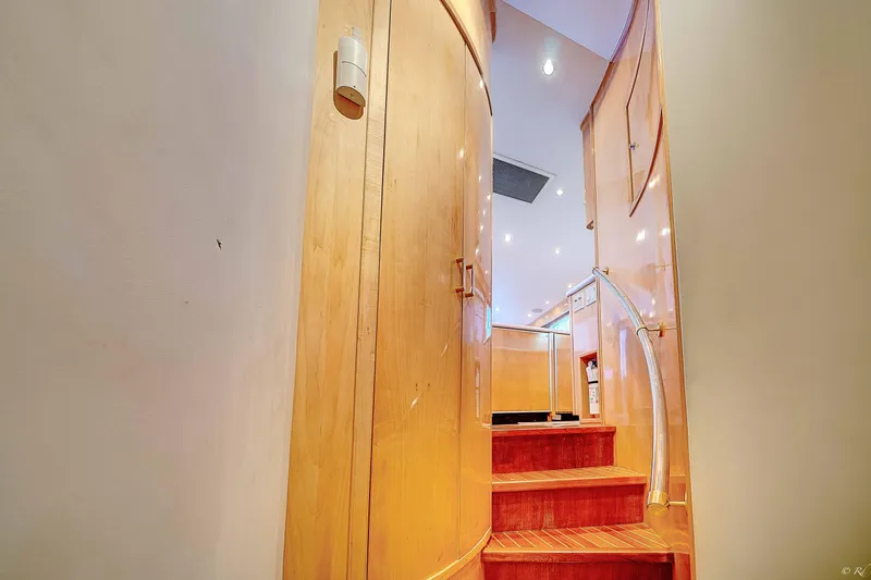  Yacht Photos Pics Interior stairs of 1998 Hatteras 60 Convertible yacht with wooden finish.