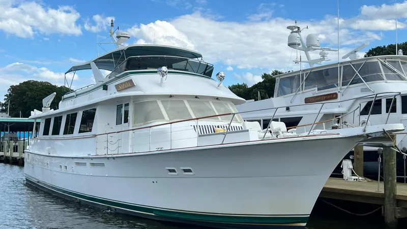 Sea Owl Yacht Photos Pics 1987 Hatteras Motoryacht docked, featuring classic design and spacious deck under a blue sky.
