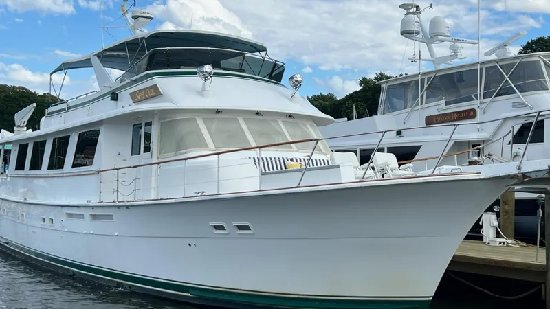 Sea Owl Yacht Photos Pics 1987 Hatteras Motoryacht docked at marina under blue sky.