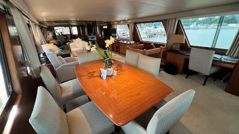 Sea Owl Yacht Photos Pics Luxurious interior of a 1987 Hatteras Motoryacht with elegant dining area and scenic windows.