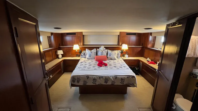 Sea Owl Yacht Photos Pics Luxurious 1987 Hatteras Motoryacht bedroom with elegant wood paneling and cozy lighting.