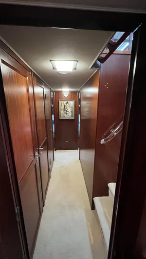 Sea Owl Yacht Photos Pics Interior hallway of a 1987 Hatteras Motoryacht with wood paneling and artwork.