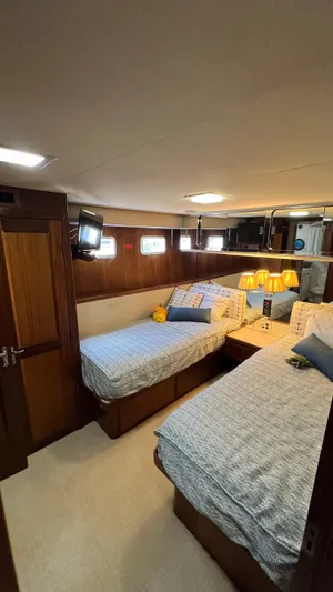 Sea Owl Yacht Photos Pics 1987 Hatteras Motoryacht cabin with twin beds, wood paneling, and cozy lighting.