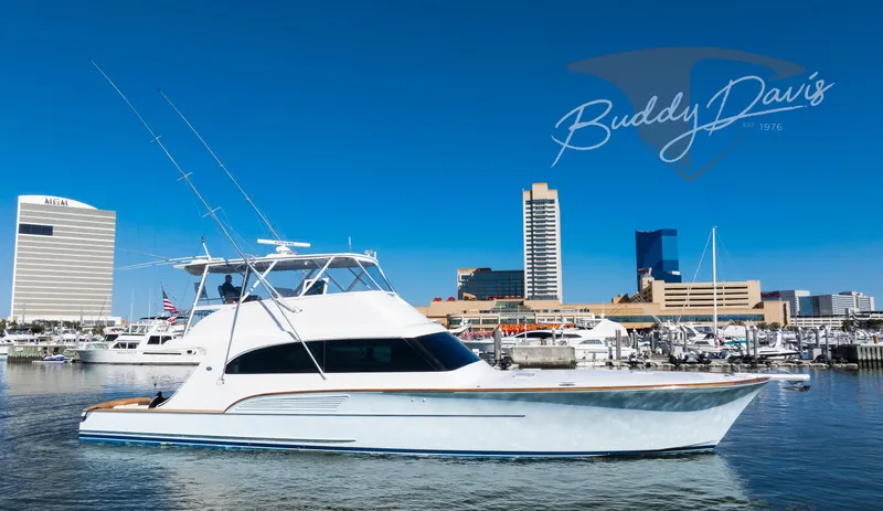  Yacht Photos Pics 2009 Buddy Davis Sportfish yacht in harbor with skyline backdrop.