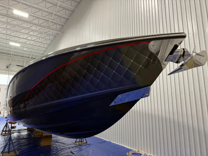 Incognito Yacht Photos Pics 2022 Cigarette 42 Nighteagle boat in a warehouse, sleek design with red accents.