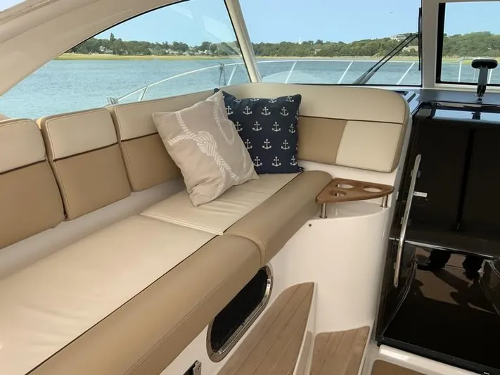 Intuition Yacht Photos Pics Luxurious interior of 2013 Tiara Yachts 36 with beige seating and nautical-themed pillows.