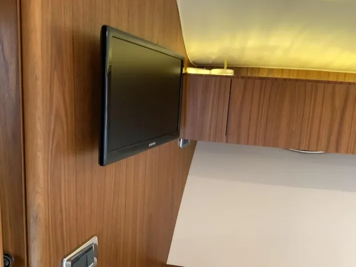 Intuition Yacht Photos Pics Interior of 2013 Tiara Yachts 36 with mounted TV and wooden cabinetry.