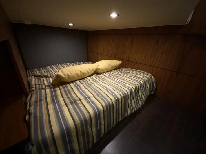 Intuition Yacht Photos Pics Cozy cabin interior of 2013 Tiara Yachts 36 with striped bedding and wooden walls.