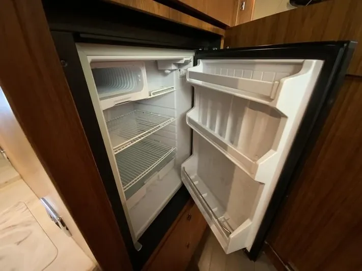Intuition Yacht Photos Pics Open refrigerator inside 2013 Tiara Yachts 36, showcasing spacious interior and shelving.